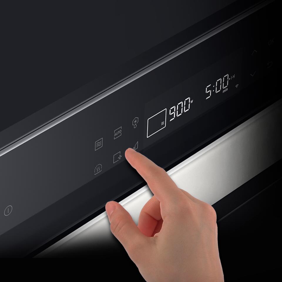 Рука пользователя управляет интуитивно понятной панелью управления встроенной микроволновой печью, доступной в сети «Медиа Эксперт».