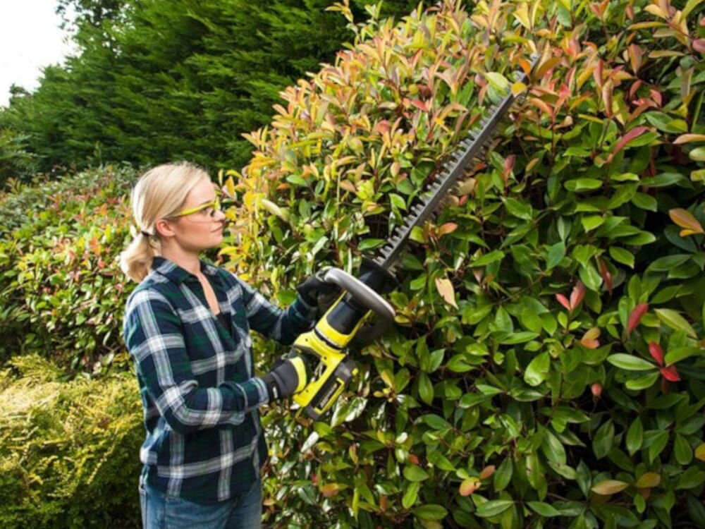 Akumulator RYOBI RY36B40B 4.0Ah 36V, wydajność, energia, efektywność, napięcie, Kobieta przycina krzew sekatorem ryboi z wpiętym akumulatorem