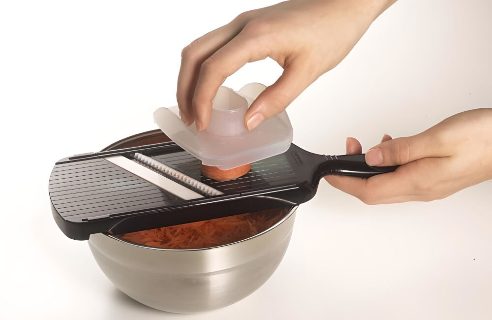 Krajalnica do warzyw KYOCERA ALE120027 obudowa z tworzywa sztucznego ABS elegancki czarny kolor wycięcia na końcach założenie na brzegi miski osłona na palce bezpieczeństwo możliwość mycia w zmywarce utrzymanie porządku przyspieszenie przygotowania posiłków  