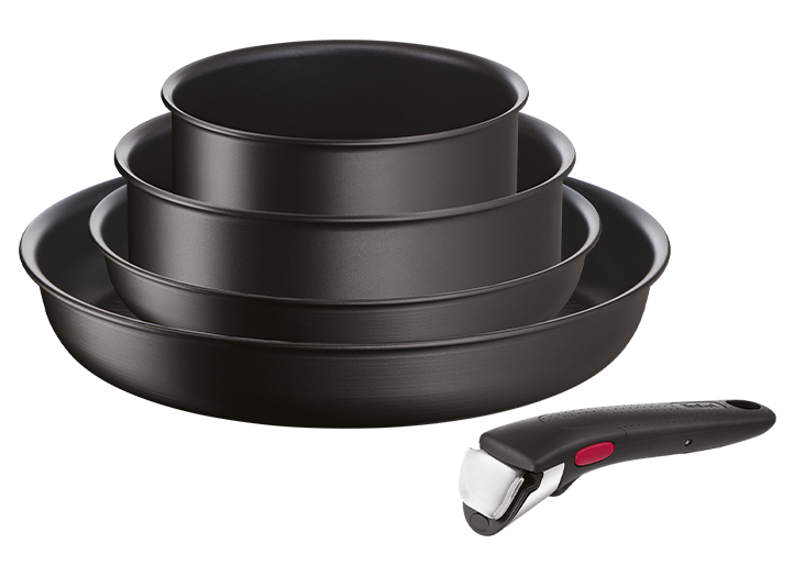 Na obrazie widoczny jest zestaw czterech czarnych patelni o różnych rozmiarach, ułożonych jedna na drugiej. Obok znajduje się czarny uchwyt z czerwonym przyciskiem.