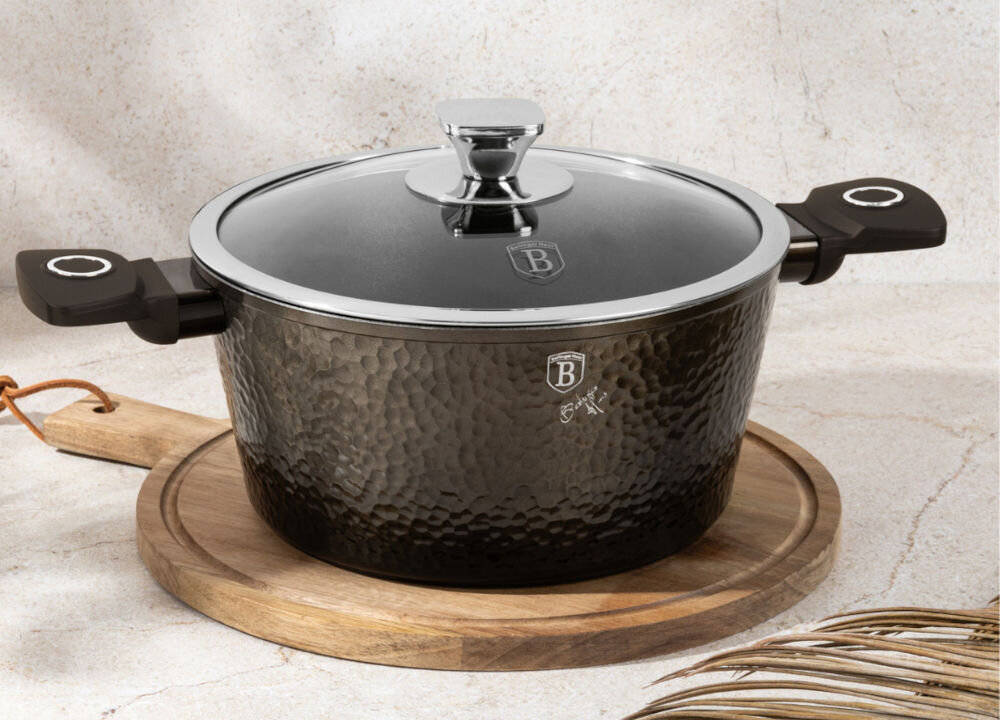 Garnek BERLINGER HAUS Primal Gloss Collection BH-6573 28 cm garnek stoi na desce kolor czarny zamknięty pokrywką srebrne elementy na pokrywce para wydzielająca się z garnka jasne tło średnica 28 cm pojemność 6,1 l stylowy design praktyczne rozwiązania seria PRIMAL GLOSS COLLECTION z efektem młotkowania estetyka wygoda podczas gotowania we współczesnych kuchniach