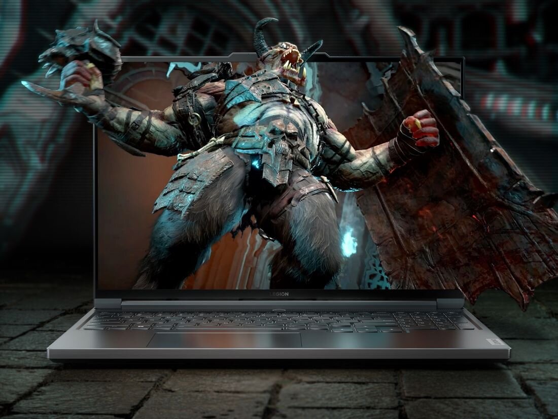 Na ekranie laptopa wyświetlany jest obraz przedstawiający fantastyczną postać z rogami i skrzydłami. Klawiatura laptopa jest widoczna na pierwszym planie.