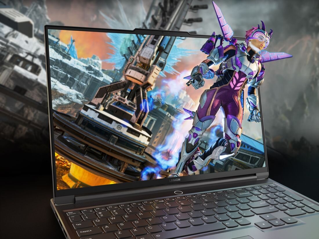 Laptop z wyświetlaczem pokazującym dynamiczną scenę z gry, przedstawiającą postać w futurystycznym stroju na tle technologicznej struktury. Na obudowie laptopa widoczne jest logo \'LEGION\'.