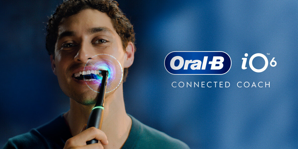 Osoba używa szczoteczki magnetycznej Oral-B iO 6, a obok widoczne jest logo Oral-B iO 6 oraz napis \'CONNECTED COACH\'.