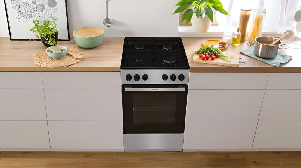 KUCHNIA GORENJE MEK3011SB lifestyle kuchnia rodzina dziecko akcesoria plastyczne na stole kuchenka w tle kolor czarno srebrny okap półki czajnik akcesoria kuchenne na blacie