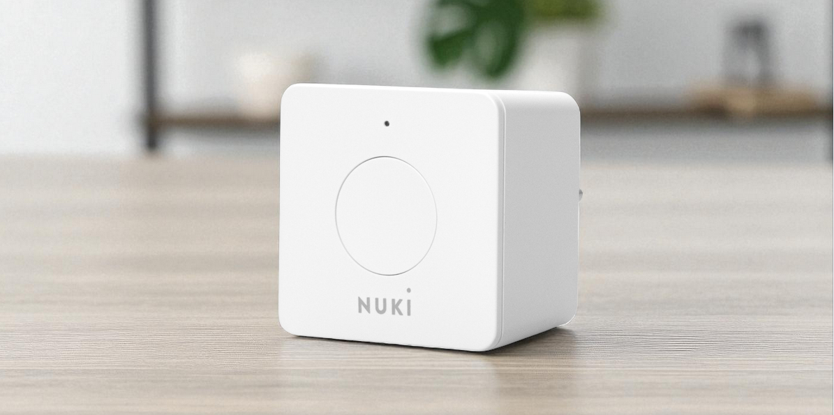 Mostek NUKI Bridge, bramka, smart lock, zarządzanie, wifi, na podłodze z paneli stoi monstek nuki