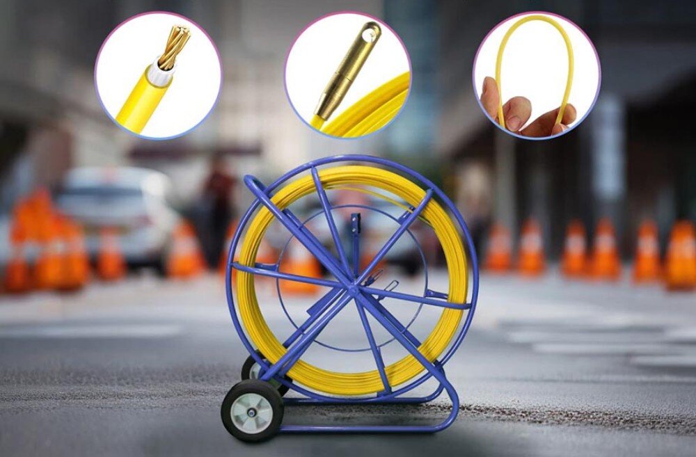 Pilot do przeciągania kabli EXTRALINK 15999 Niebieski stojak z żółtym przewodem ustawiony na ulicy z pachołkami drogowymi w tle, z trzema okrągłymi zbliżeniami pokazującymi szczegóły końcówki, przekroju i elastyczności przewodu