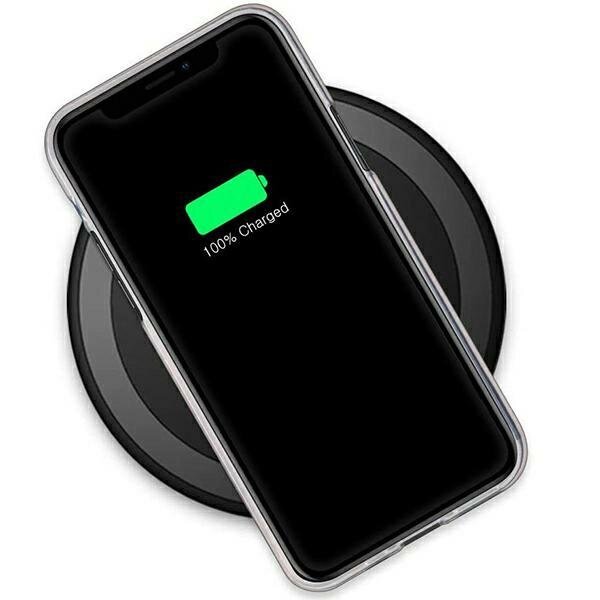 Telefon w przezroczystym etui leży na okrągłej ładowarce bezprzewodowej. Na ekranie telefonu widoczny jest zielony symbol baterii z napisem \'100% Charged\'.