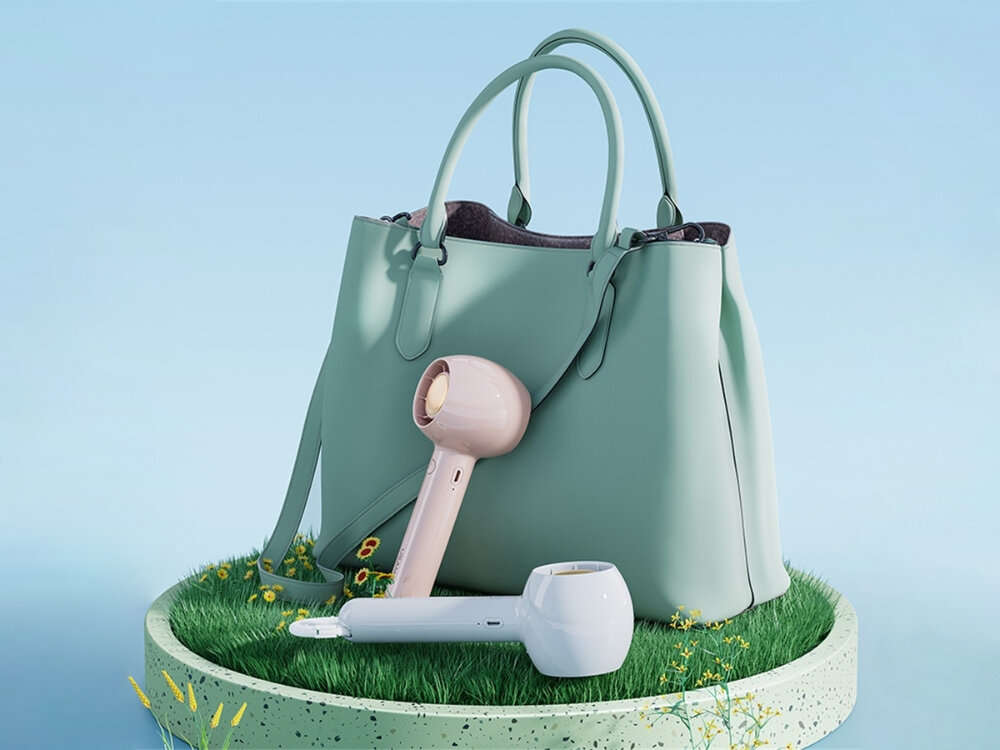 USAMS Candy Series mini wentylator ręczny Biały i różowy przenośny wentylator ręczny Usams o nowoczesnym designie na podstawce z trawy obok miętowej torebki.