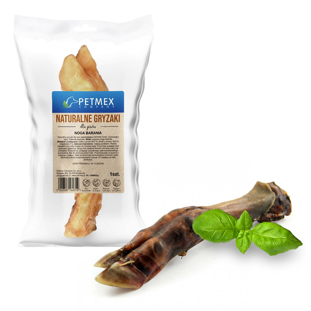 Na obrazie widoczny jest produkt w przezroczystym opakowaniu z etykietą \'PETMEX COMPANY NATURALNE GRYZAKI dla psów NOGA BARANIA\'. Obok opakowania leży naturalny gryzak w postaci nogi baraniej oraz liść bazylii.
