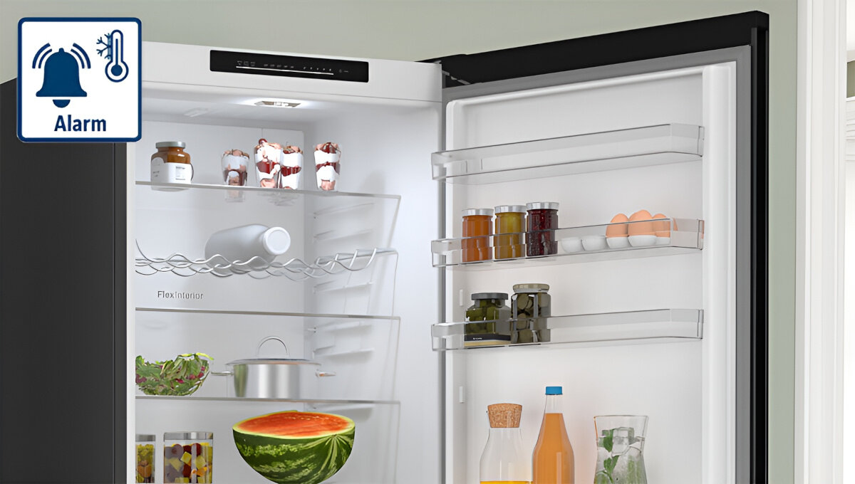 LODÓWKA BOSCH KGN49LBCF BLACK Zdjęcie przedstawia otwartą lodówkę z różnorodnymi produktami na półkach oraz ikoną alarmu temperatury w lewym górnym rogu. Grafika symbolizuje funkcję ostrzegającą o nieprawidłowych warunkach wewnątrz chłodziarki alarm sygnał ostrzeżenie