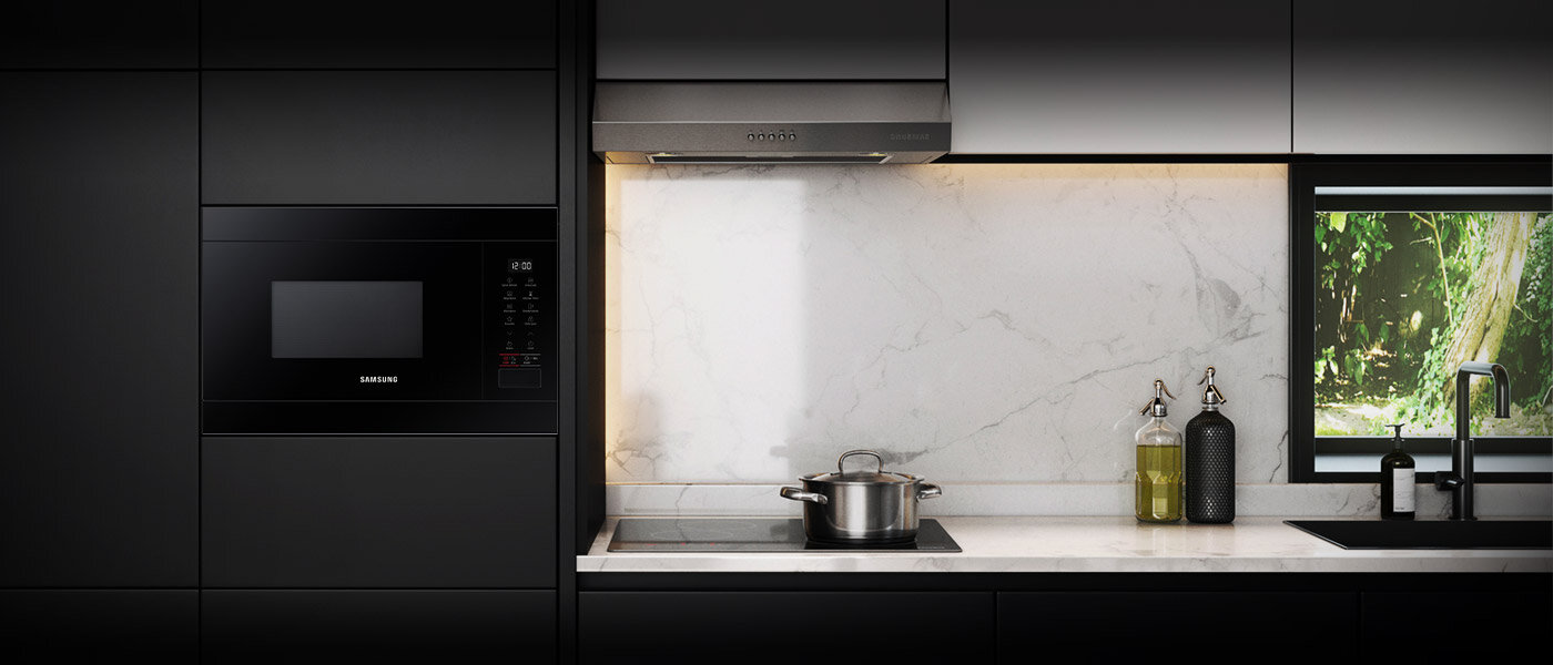 Kuchenka mikrofalowa Samsung MS22T8254AB/E1 dostępna w ofercie Media Expert została zaprezentowana w eleganckiej nowoczesnej kuchni o czarnym wykończeniu zabudowy kontrastującym z blatem z białego marmuru