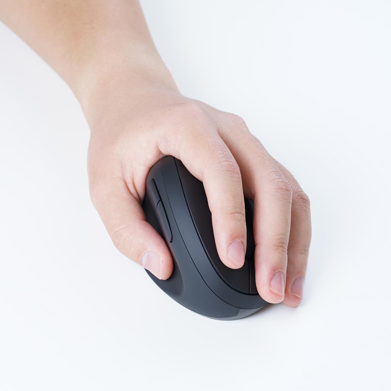 Osoba trzyma czarną, wertykalną mysz komputerową na białym tle. Mysz ma ergonomiczny kształt i widoczny przycisk boczny.