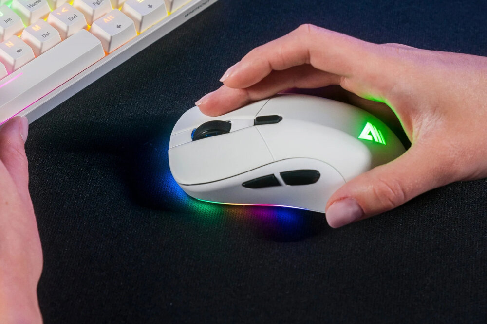 Dłoń na myszce gamingowej SAVIO Rift White z podświetleniem RGB obok klawiatury