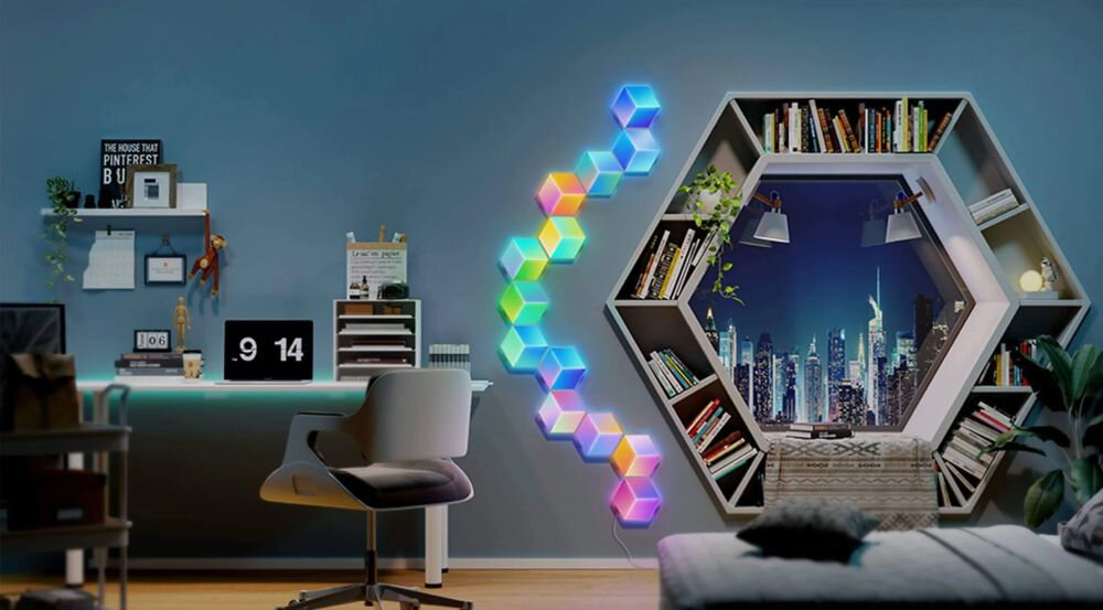 Panel świetlny GOVEE H6066 Glide Hexa Pro Wi-Fi + Bluetooth panele na ścianie w pokoju pomiędzy regałem z książkami a biurkiem Panele świetlne RGBIC z funkcją płynnego przechodzenia kolorów między modułami