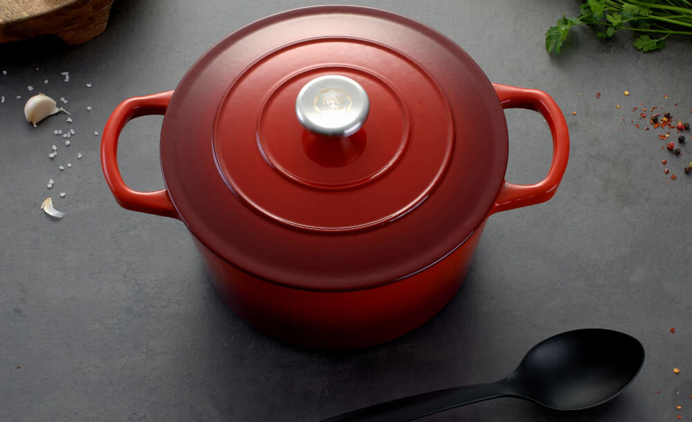 Garnek MG HOME Infinito 22 cm czerwony garnek stoi na ciemnym blacie zamknięty pokrywką łyżka leży obok 31,6 x 23 x 12 cm) średnica 22 cm pojemność 4 litrów jakość trwałość funkcjonalność w każdej kuchni solidne żeliwo pokryty emaliowaną powłoką wewnątrz do długiego gotowania duszenia oraz zapiekania w piekarniku  przystosowany do intensywnego użytkowania równomierne rozprowadzanie ciepła kontrolowanie procesu przygotowywania potraw wygoda praktyczne narzędzie kuchenne optymalne efekty gotowania  