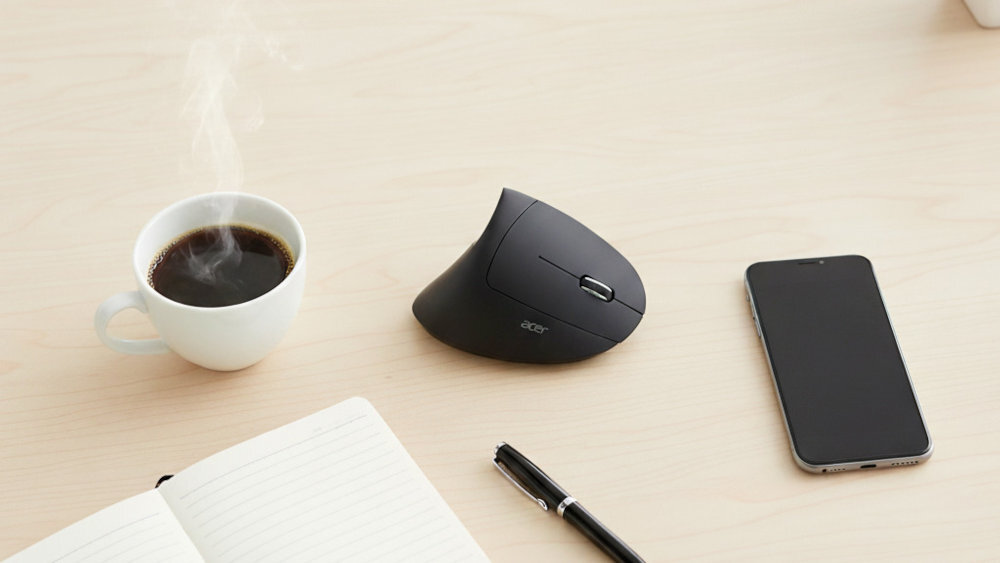 Mysz ACER Vertical - Czarna mysz komputerowa na jasnym biurku obok kubka z parującą kawą, notesu, długopisu i smartfona.