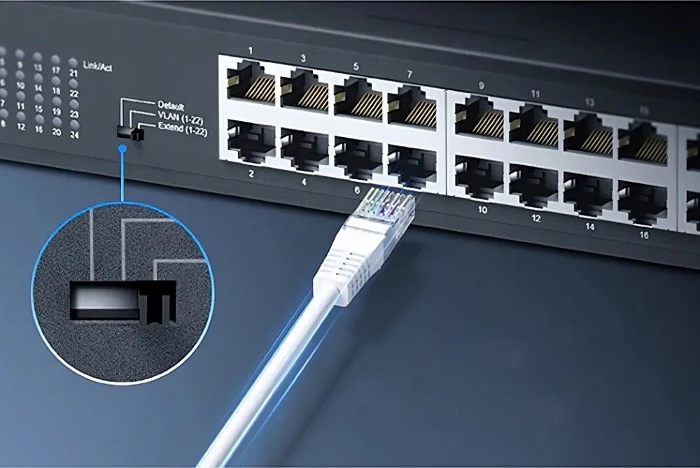Switch CUDY GS1024 Zbliżenie na przedni panel przełącznika sieciowego z podłączonym kablem Ethernet. Widoczny przełącznik trybu VLAN i porty oznaczone numerami, przeznaczenie, zastosowanie, standardy