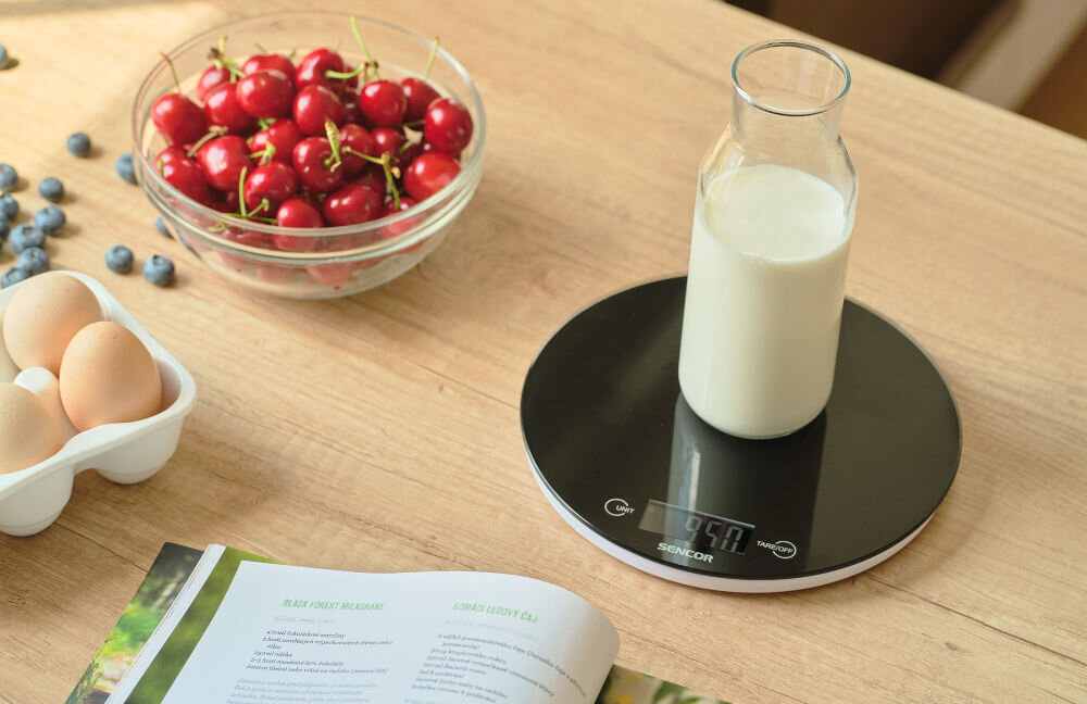 Waga kuchenna SENCOR SKS 5330 Czarny czarna okrągła waga leży na blacie wyświetlacz przyciski karafka z mlekiem na wadze z hartowanego szkła Kompaktowe wymiary (20,5 × 20,5 × 1,8 cm) w małych kuchniach zasilana dwiema bateriami litowymi CR2032 na stabilnej, równej powierzchni funkcjonalny pomocnik w kuchni  