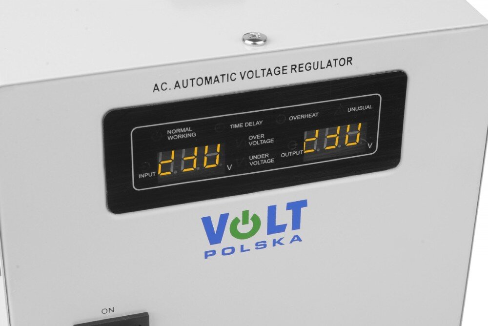 Stabilizator napięcia VOLT AVR Pro Widok z przodu na biały stabilizator napięcia, prezentujący centralnie umieszczony ekran cyfrowy z odczytami napięcia, logo marki pod nim, czarny przełącznik po lewej stronie oraz poziome rzędy otworów wentylacyjnych na dole
