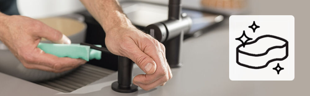 Zlewozmywak FRANKE Mythos MTG 611-100 114.0675.937 Kamienny szary osoba korzystająca z dozownika do mydła ikona symbolizująca czystość łatwość pielęgnacji czyszczenie ściereczką z mikrofibry spray FRANKE Colored Sink Cleaner