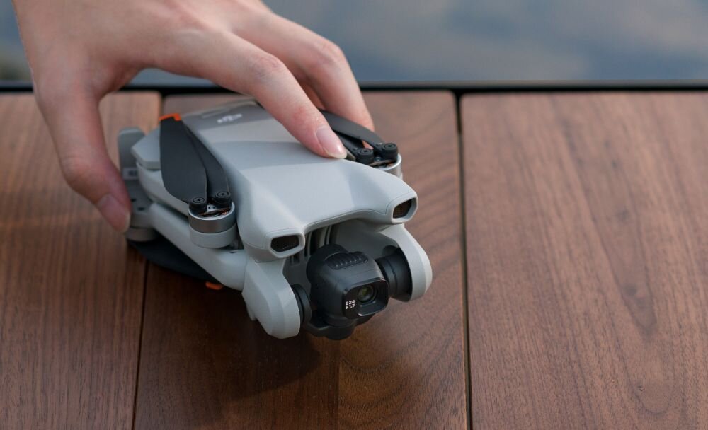 Dron DJI Mini 3 bateria lot sterowanie akrobacje czas lotu zasięg funkcje lądowanie kamera rozdzielczość filmy zdjęcia nagrywanie jakość ładowanie aplikacja przesył pilot śmigła stabilizacja fotografia waga wymiary konstrukcja obudowa korpus ramiona silnik