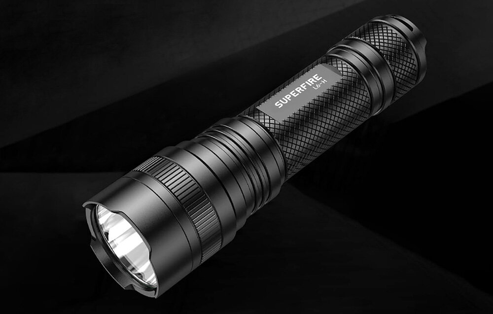 Czarna latarka z napisem \'SUPERFIRE L6-H\' na korpusie, z widoczną teksturą i reflektorem z przodu.