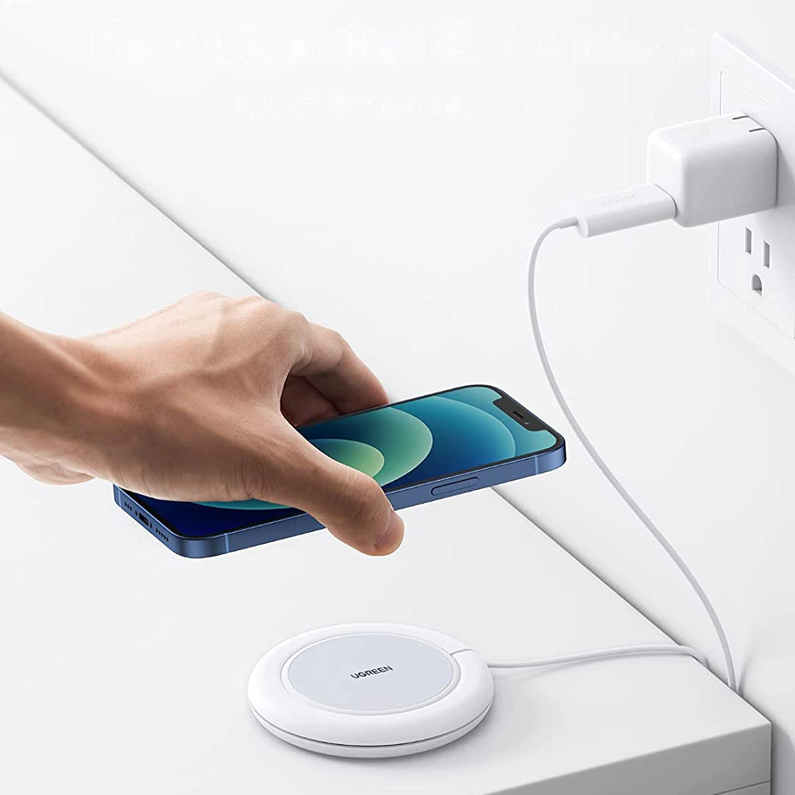 Osoba trzyma smartfon nad białą, okrągłą ładowarką bezprzewodową z napisem \'UGREEN\'. Ładowarka jest podłączona kablem USB-C do gniazdka elektrycznego.