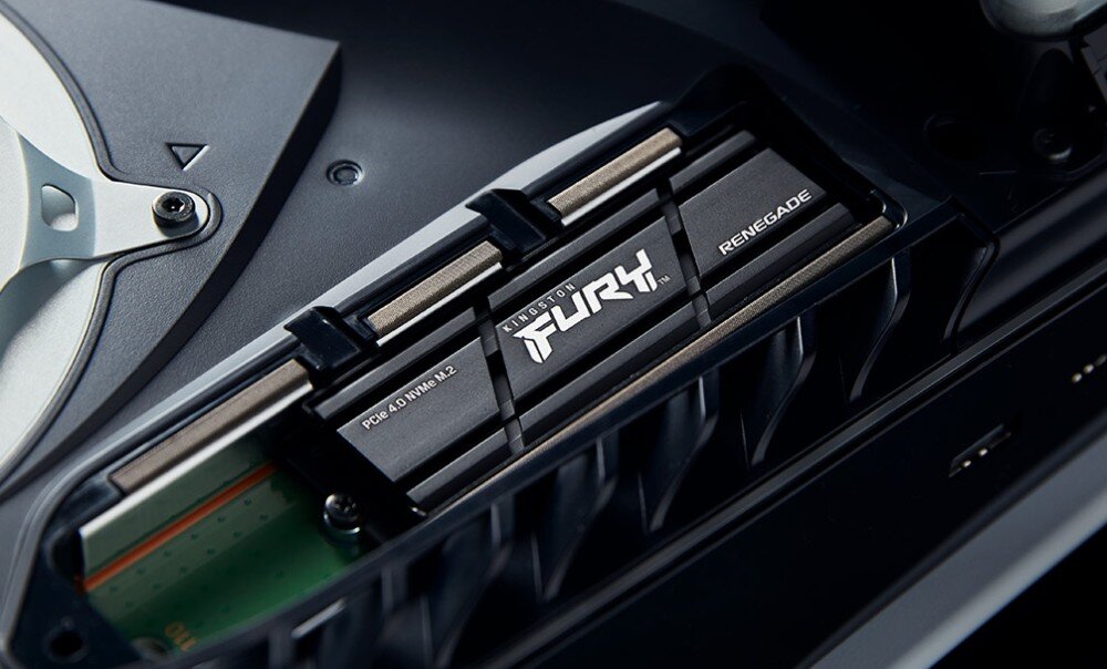 Dysk KINGSTON Fury Renegade Podłużny dysk komputerowy z napisem 'FURY' umieszczony wewnątrz czarnej wnęki urządzenia elektronicznego, widoczny fragment metalowego elementu obok, radiator, konstrukcja, żywotność