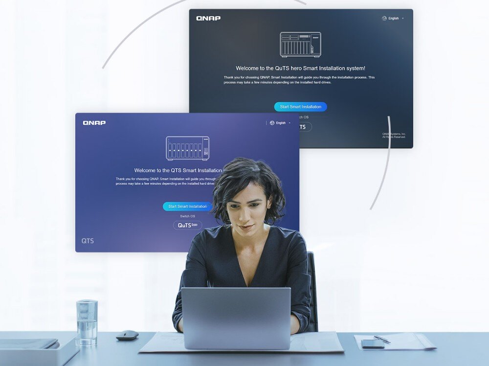 Serwer plików QNAP TS-1655-8G Kobieta siedząca przy biurku z laptopem, w tle widoczne ekrany instalatora systemów z przyciskiem 'Start Smart Installation', system, funkcje, zalety, wsparcie