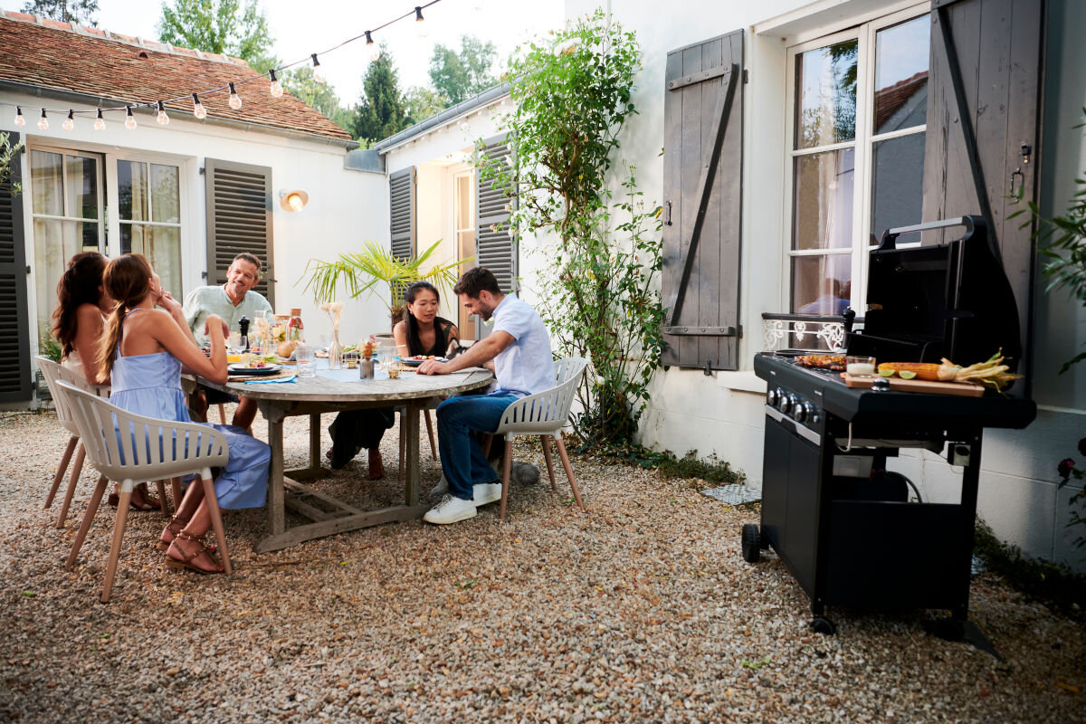 Grill gazowy CAMPINGAZ Select EXS Seria 3 9 + 2.3 kW 62 x 40 cm, ogród, smażenie, grillowanie, komfort, grupa znajomych siedzi przy grillu na tarasie