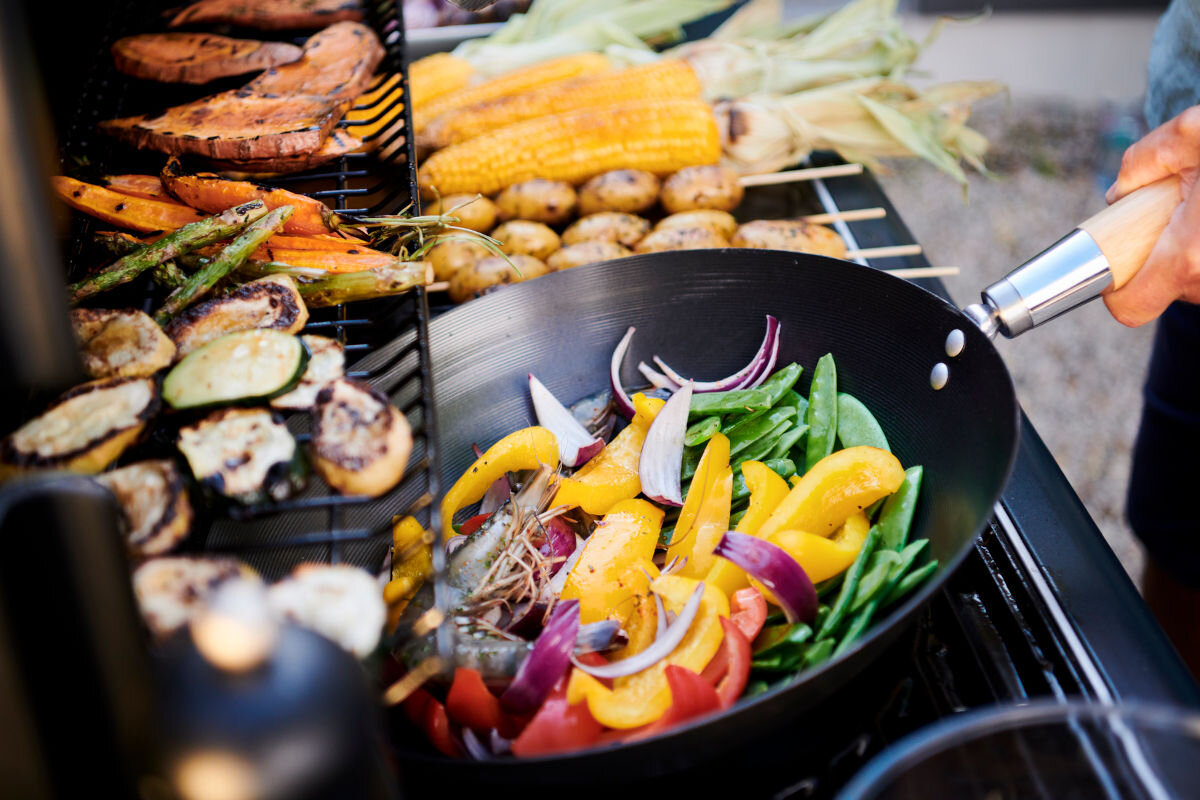 Grill gazowy CAMPINGAZ Select LX PLUS Seria 4 12 kW 46 x 72 cm, wkłady, wymienne, rozwiązanie, uniwersalne, zbliżenie na ruszt grilla na którym są przygotowywane różnego rodzaju potrawy