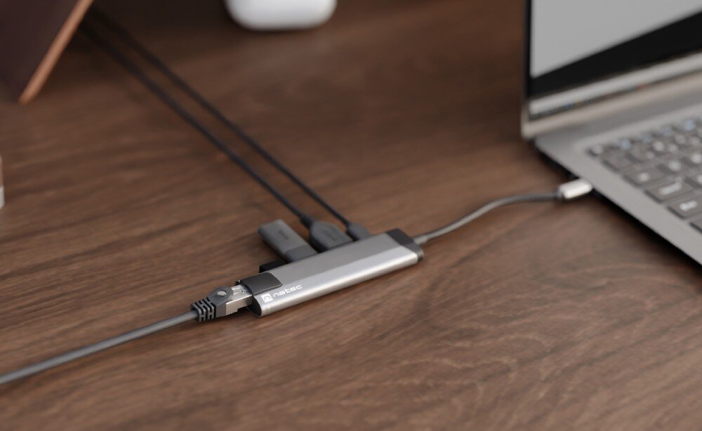 Hub NATEC Fowler Go 5w1 Adapter podłączony do laptopa na drewnianym biurku z wieloma podłączonymi kablami.