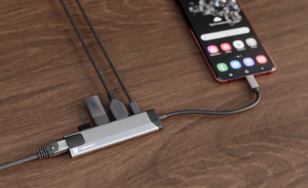 Hub NATEC Fowler Go 5w1 Adapter z wieloma portami połączeniowymi podłączony do smartfona na drewnianym biurku.