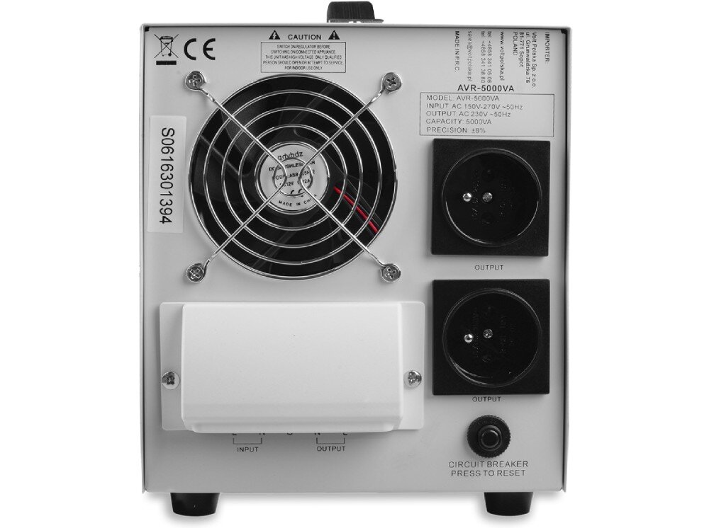 Stabilizator napięcia VOLT AVR Tylny panel urządzenia z czarnym wentylatorem za metalową osłoną oraz dwoma gniazdami wyjściowymi po prawej stronie. Na dole znajduje się biała pokrywa złącz i przycisk resetowania bezpiecznika, a w górnym rogu umieszczono etykietę z parametrami zasilania