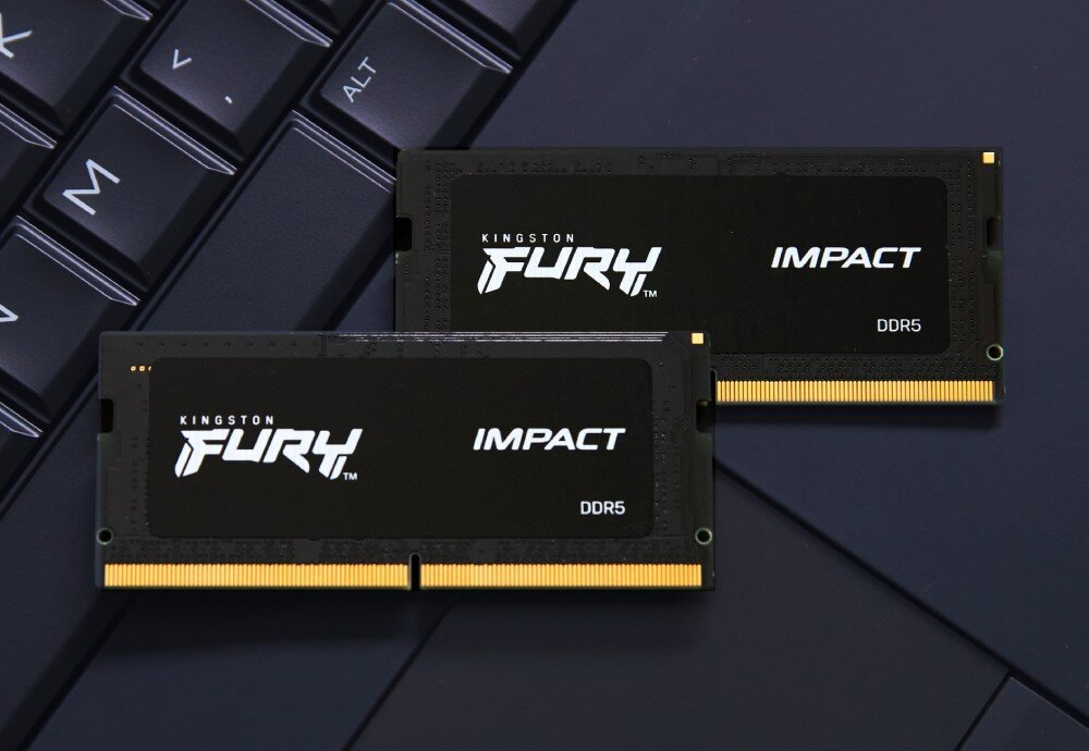 Pamięć RAM KINGSTON Fury Impact Dwa moduły pamięci RAM ułożone jeden na drugim na tle czarnej klawiatury laptopa