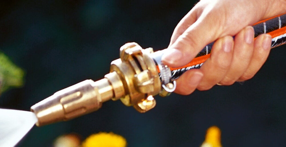 Pistolet zraszający GARDENA 07131-20 zbliżenie na łączenie pistoletu i węża osoba podlewa rośliny podlewanie roślin czyszczenie powierzchni ogrodowych kompatybilności ze standardowymi szybkozłączami GARDENA pasuje do węży o średnicy 19 mm (3/4”) łączy się z szybkozłączem mosiężnym zapobiega przeciekaniu i przesuwaniu się