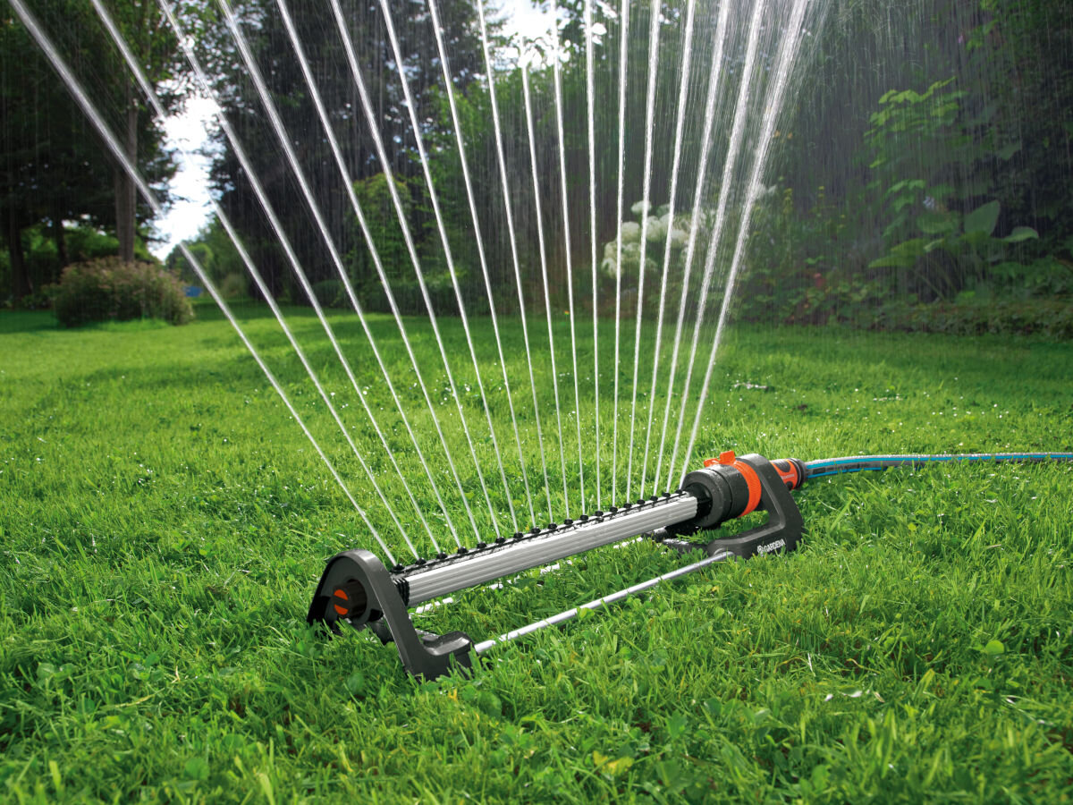Zraszacz GARDENA Aqua L 18704-20, podlewanie, woda, ogród, zraszacz, w tle ogród, na pierwszym planie zraszacz podlewa trawnik