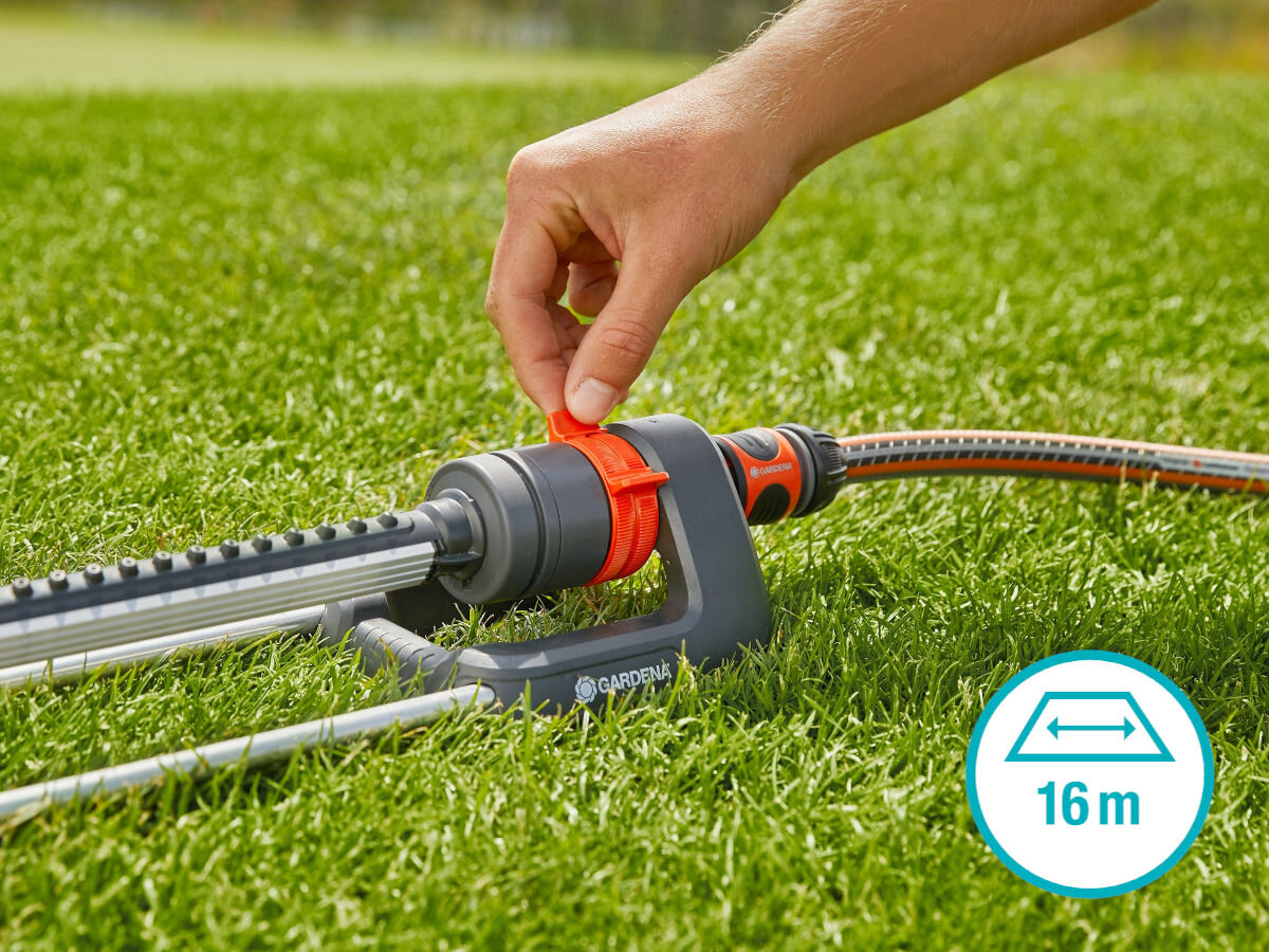 Zraszacz GARDENA Aqua L 18704-20, zasięg, podlewanie, natężenie, trawnik, dłoń obsługuje zraszacz na trawniku, obok logotyp pracy szerokości zraszacza