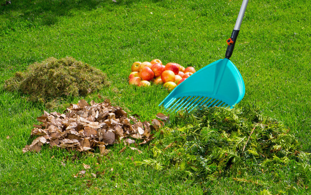 Szufla GARDENA Combisystem 3120-20 zbliżenie na szuflę na trawie wkoło odpadkiogrodowe i jabłka do grabienia liści zbierania ścinków żywopłotu usuwania opadłych owoców zintegrowana funkcja sita przesiewanie ziemi i oddzielanie nieczystości