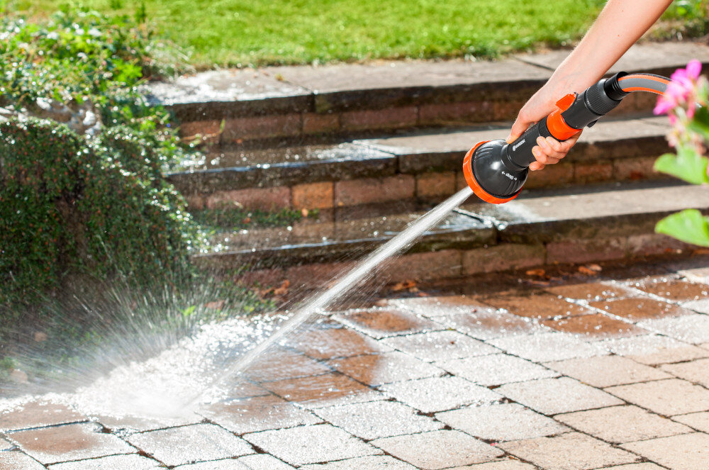 Zraszacz prosty GARDENA Profi-System trzyfunkcyjny z sitkiem 02847-20 ogród taras osoba myje płytki tarasowe w tle trawnik kwiaty do podlewania roślin mycia powierzchni do użytku z długimi wężami i pompami oszczędza czas i wysiłek