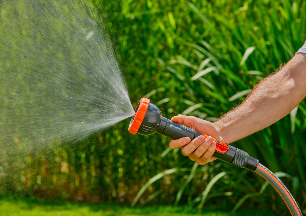 Zraszacz prosty GARDENA Profi-System trzyfunkcyjny z sitkiem 02847-20 ogród zielone rośliny osoba trzyma zraszacz w dłoni podlewa rośliny miękki gumowy pierścień długa żywotność odporność na uszkodzenia mechaniczne