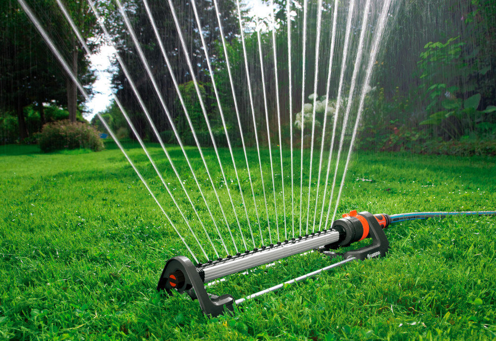 Zraszacz GARDENA Aqua S 18700-20 trawnik zraszacz na trawniku w tle drzewa kwiaty możliwość regulacji zasięgu i szerokości pracy rozprowadza wodę równomiernie eliminuje problem przesuszeń i nadmiernego nawodnienia oszczędność wody