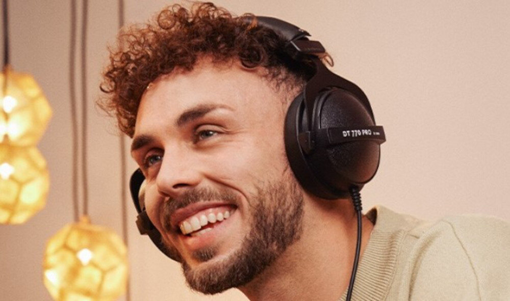 Słuchawki nauszne BEYERDYNAMIC DT 770 Pro 80 Ohm pasmo 5-35000 Hz Bass Reflex, osoba z założonymi słuchawkami nausznymi