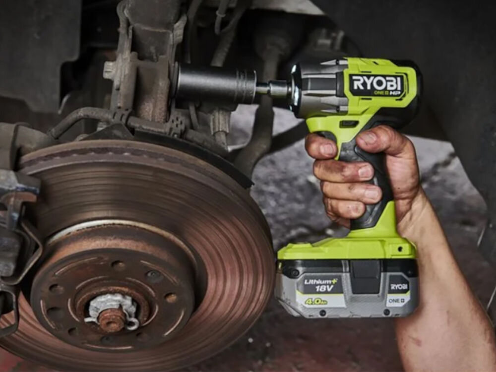 Akumulator RYOBI RB1840X 4Ah 18V, zasialnie, akumulator, energia, Wkrętarka pneumatyczna pracuje przy kole auta, do wkrętarki wpięty akumulator