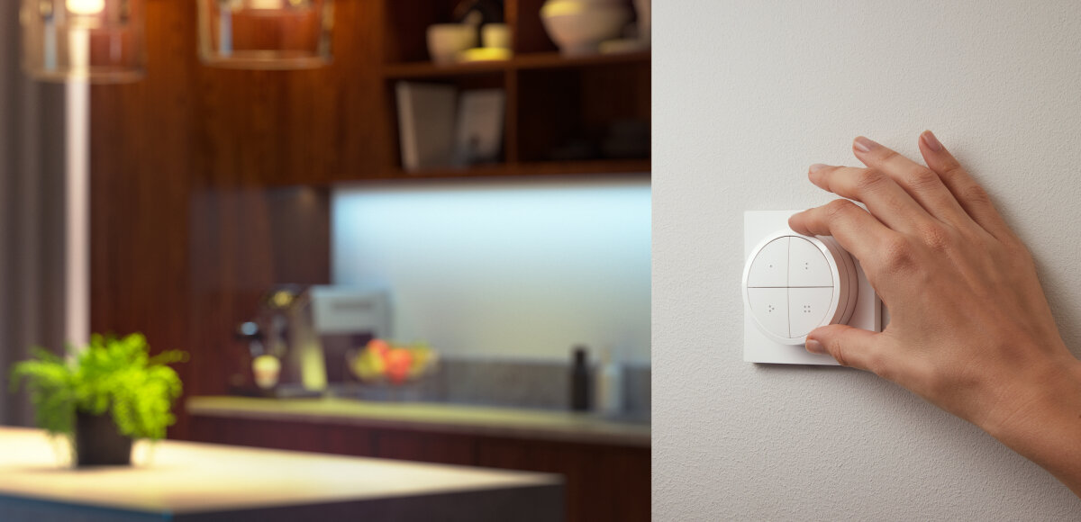 Przełącznik PHILIPS HUE Tap dial Switch Biały, pokrętło, przyciemnianie, rozjaśnianie, przełącznik, dłoń reguluje przełącznik zamontowany na ścianie, oświetla kuchnię