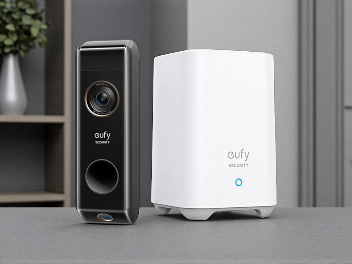 Wideodomofon EUFY S330 E8213G11 Bezprzewodowy Wi-Fi, obraz 2K, detekcja ruchu, HDR, noc, Wideodomofon EUFY S330 obok białej stacji HomeBase, całość na tle wnętrza mieszkania