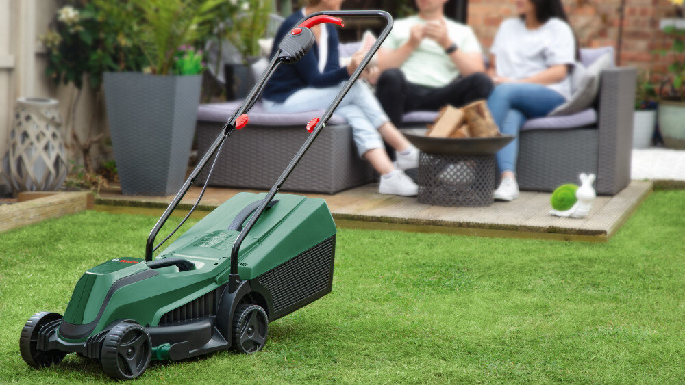Kosiarka akumulatorowa BOSCH EasyMower 18V-32-200 06008B9D00 kosiarka na trawniku w tle o ogród rośliny zadbany trawnik piękna trawa mobilność zasilanie akumulatorowe