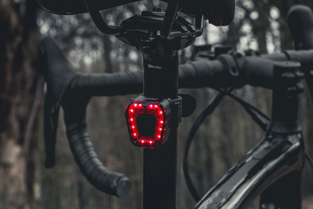 Lampka rowerowa VAYOX VA0048 zamontowana z tyłu roweru włączone światło 14 diod smd zasięg do 200 metrów