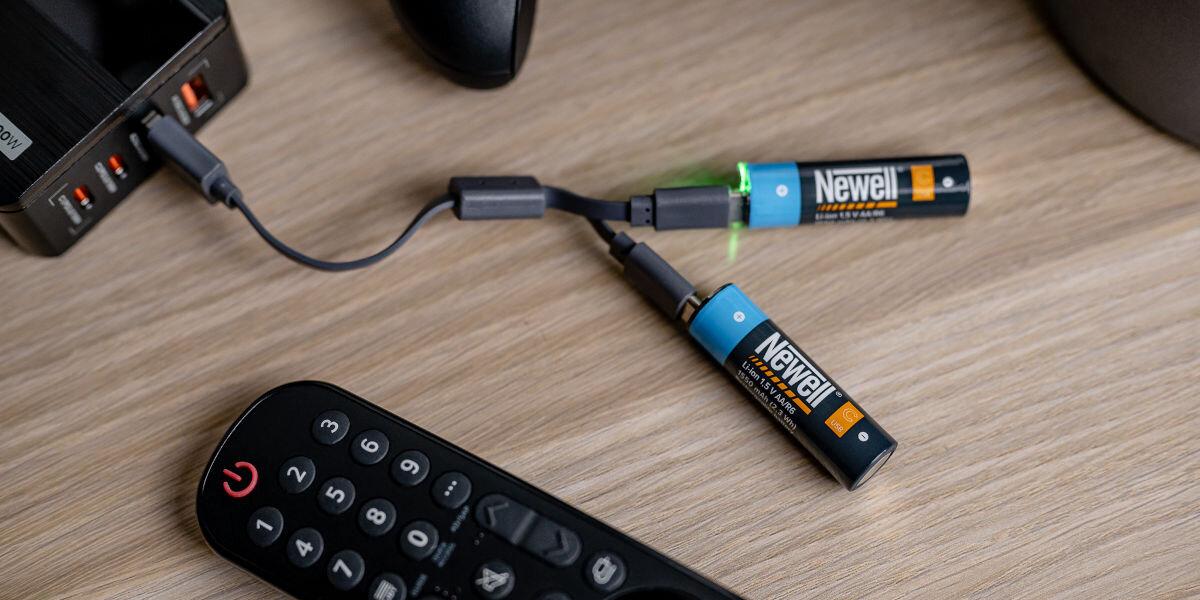 Akumulatorki AA 1550 mAh NEWELL (2 szt.), energia, AA, solidność, wygoda, Akumulatorki leżą na blacie i ładowane są kablem usb przez powerbank
